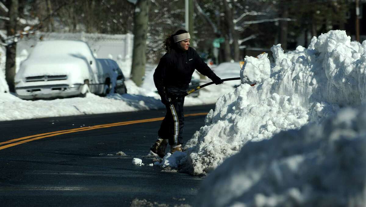 A woman clears off her car in Stamford, Conn., on Saturday, February 9, 2013.