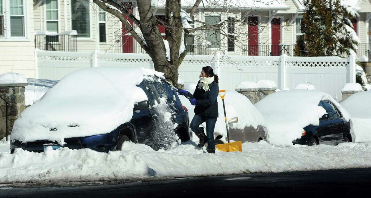 A woman clears off her car in Stamford, Conn., on Saturday, February 9, 2013.