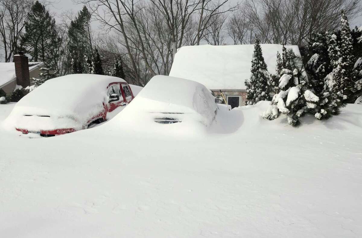 Cars remain buried in snow on Burroughs Rd. in Fairfield, Conn. on Saturady, Feb. 9, 2013. An overnight blizzard dumped over two feet of snow on the area.