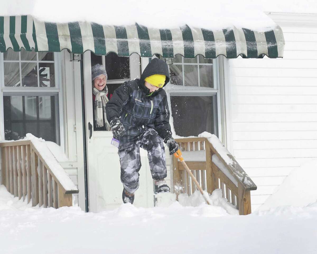 Karen Drena watches her son, Calder Waugh jump off the porch into the deep snow on Moritz Place in Fairfield, Conn. on Saturday, Feb. 9, 2013. Southwestern Connecticut was hit by one of the biggest snowstorms in history, a howling blizzard that dumped up to three feet of snow across the state.