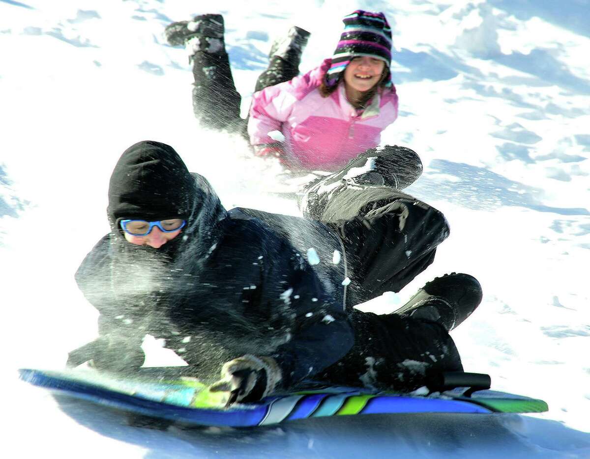Cooper Swenson, 11, slides downhill behind St. Gregory the Great Church in Danbury Saturday, Feb. 9, 2013.