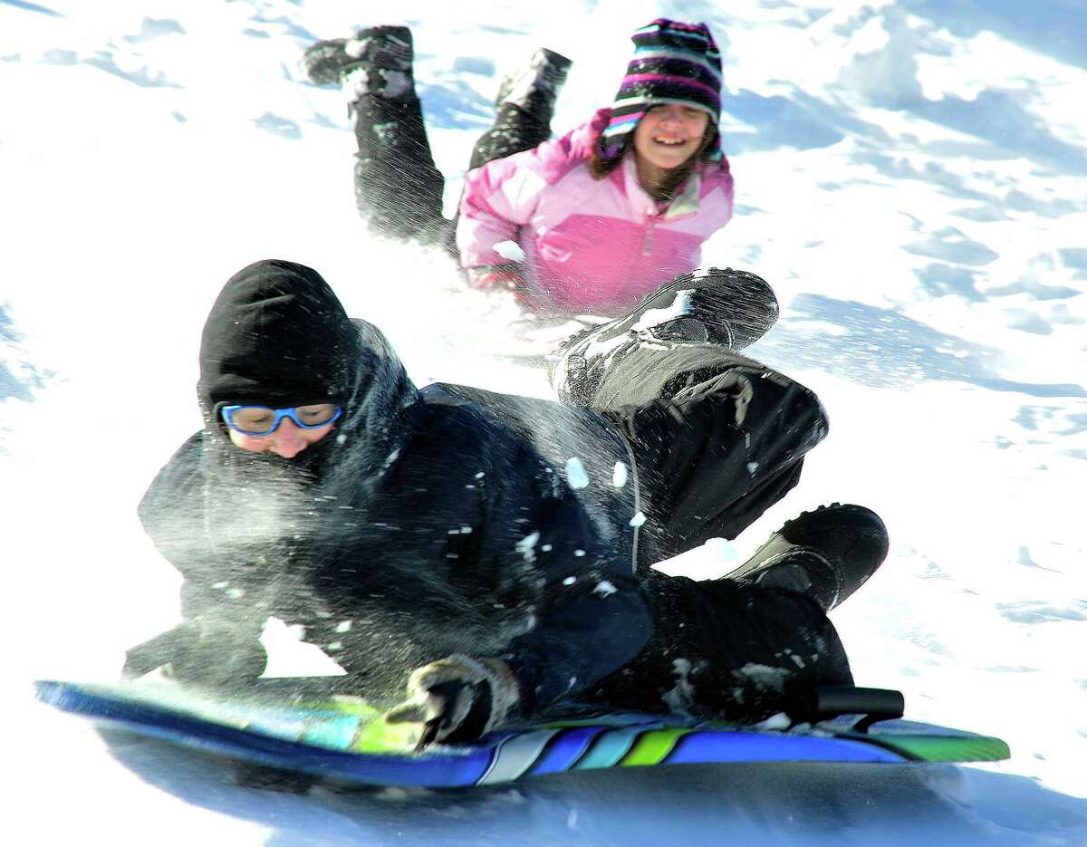 Cooper Swenson, 11, slides downhill behind St. Gregory the Great Church in Danbury Saturday, Feb. 9, 2013.