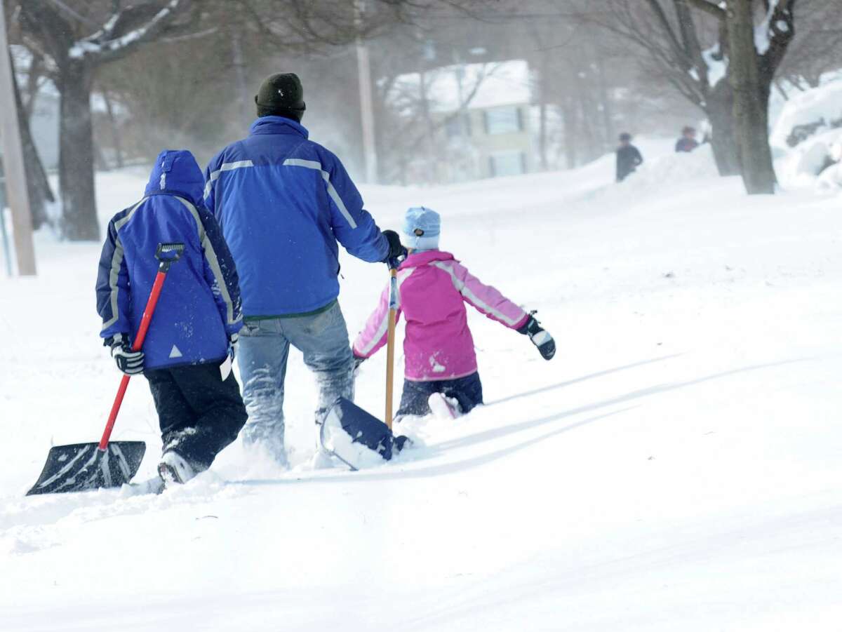 Larry Palaia and his children, Andrew and Cate head down Wilson St. to dig out grandma's driveway in Fairfield, Conn. on Saturday, Feb. 9, 2013. Southwestern Connecticut was hit by one of the biggest snowstorms in history, a howling blizzard that dumped up to three feet of snow across the state.