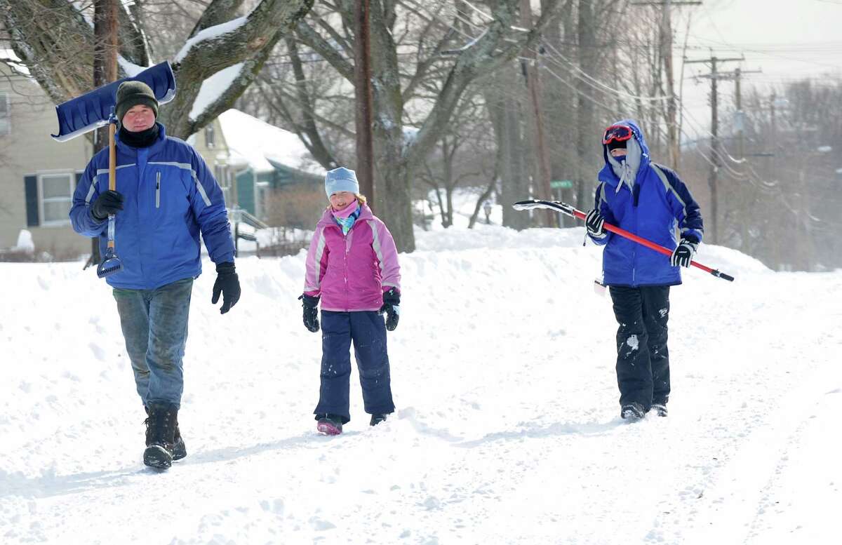 Larry Palaia and his children, Cate and Andrew head up High St. to Wilson St. to dig out grandma's driveway in Fairfield, Conn. on Saturday, Feb. 9, 2013. Southwestern Connecticut was hit by one of the biggest snowstorms in history, a howling blizzard that dumped up to three feet of snow across the state.
