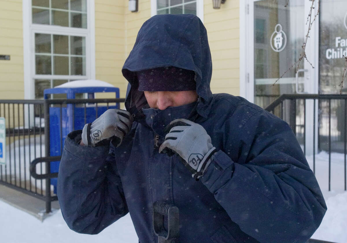 Danny Fernando bundles up before clearing out snow from the Family & Children's Aid child guidance center parking lot on West Street in Danbury on Saturday, Feb. 9, 2013.