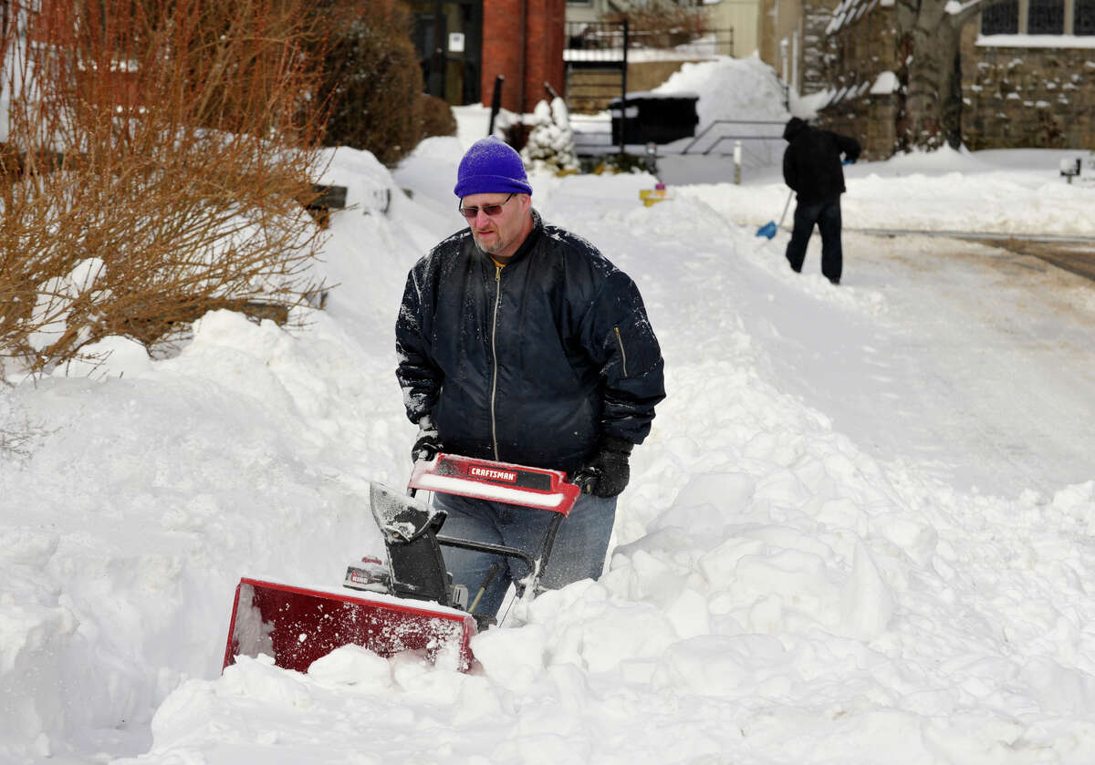 Todd Rogotzke, left, and Charles Scalzo work to remove snow from the sidewalk and a fire hydrant next to Lighthouse Ministries on Foster Street in Danbury on Saturday, Feb. 9, 2013.
