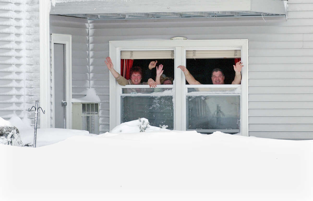 Residents Nancy and Lou Tagliatele waves from their first floor window as they have a blizard party at their home along Beach Street after a blizzard pounded the region in West Haven, Conn. on Saturday February 9, 2013.