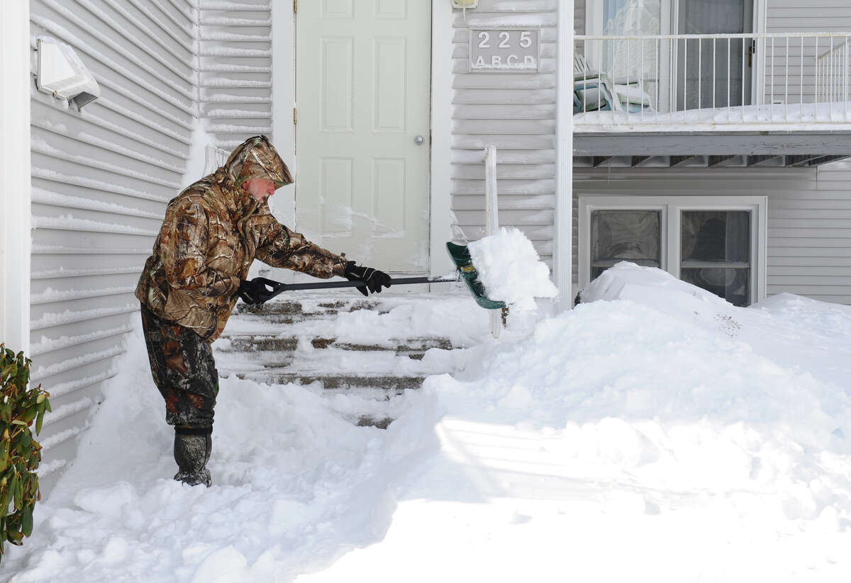 Mike Dunphy shovels his porch at his condo along Beach Street after a blizzard pounded the region in West Haven, Conn. on Saturday February 9, 2013.