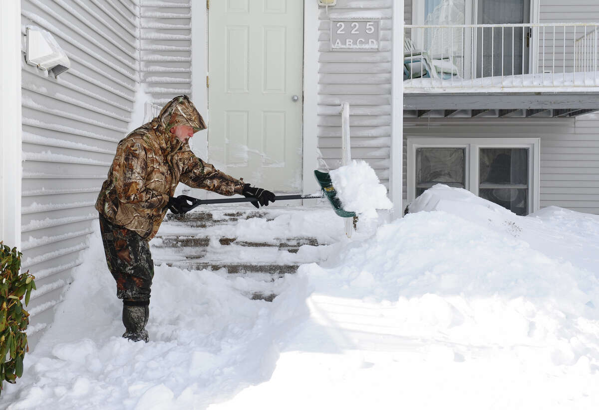 Mike Dunphy shovels his porch at his condo along Beach Street after a blizzard pounded the region in West Haven, Conn. on Saturday February 9, 2013.