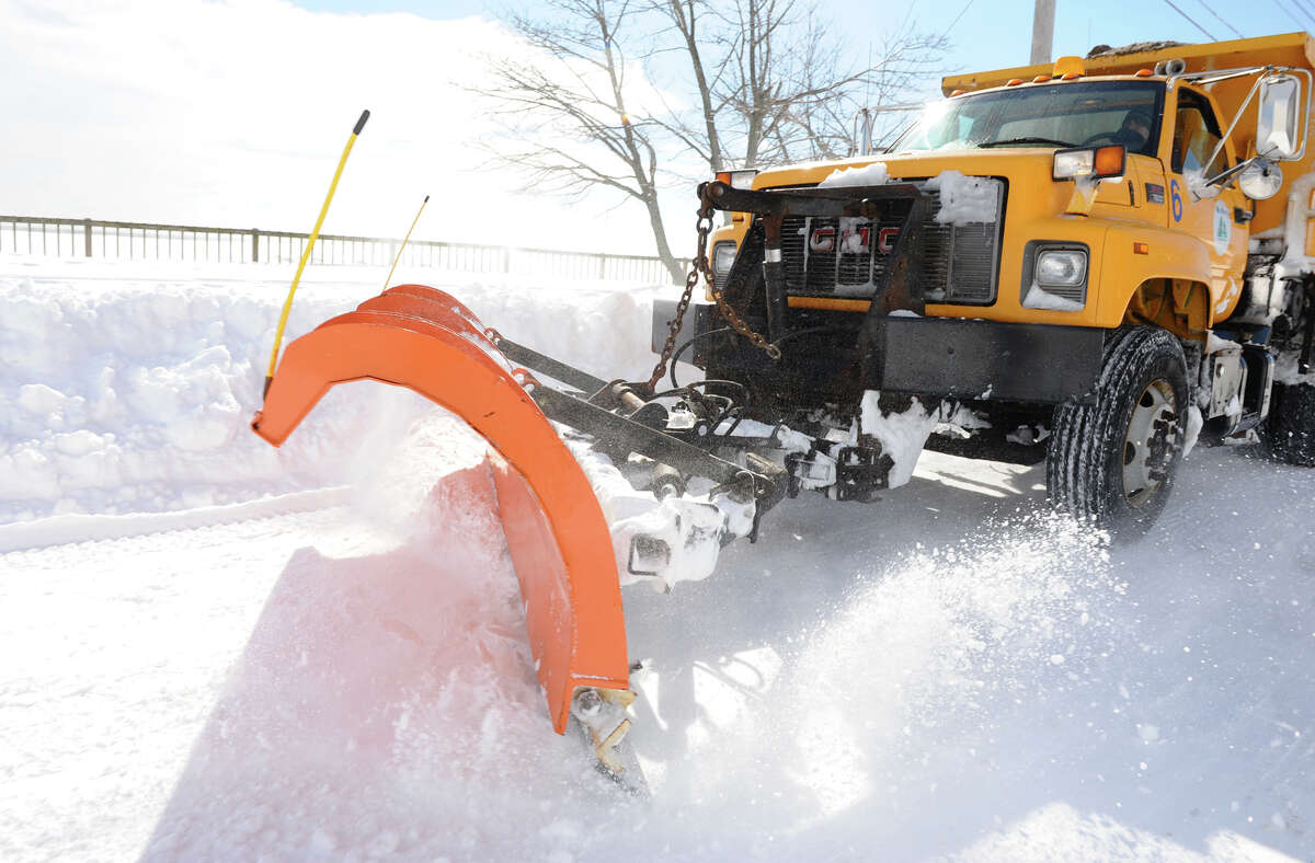 A city plow speeds by on Beach Street after a blizzard pounded the region in West Haven, Conn. on Saturday February 9, 2013.