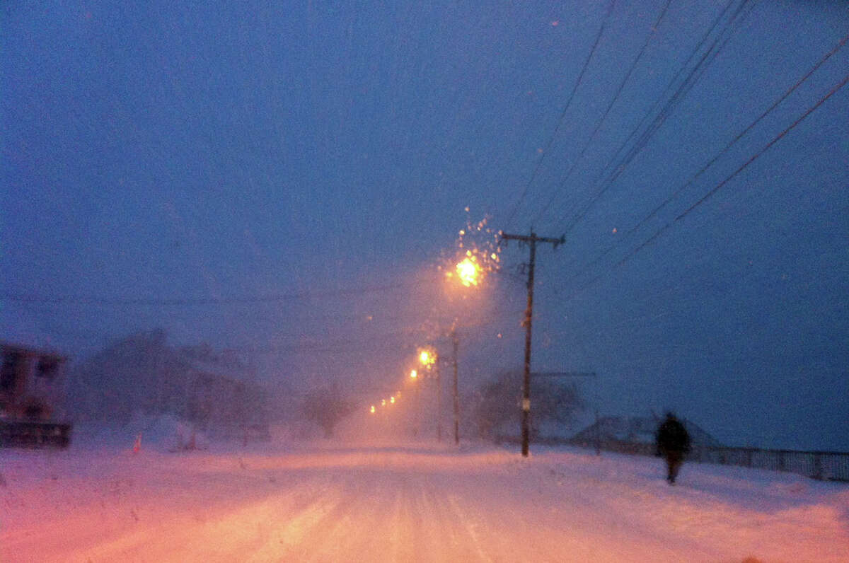 A lone pedestrian walks along Beach Street while a blizzard pounds the region in West Haven, Conn. on Friday evening February 8, 2013.