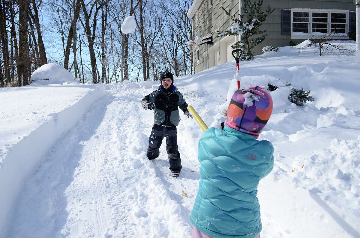 Twins Luke and Poppy Mituski play an improvised game of baseball in the snow in their driveway in Southport, CT on Sat., Feb. 9, 2013, following a blizzard that dumped up to three feet of snow across the state. The pile of snow in the upper left blankets the family car.