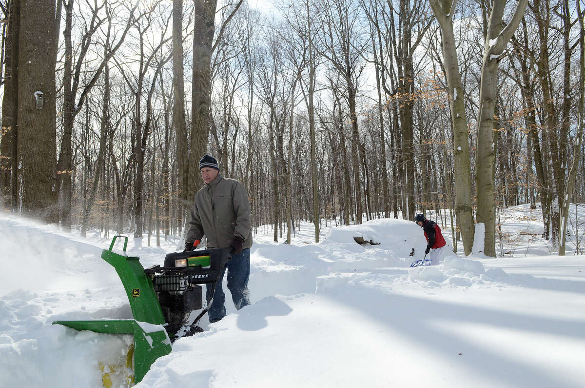 Peter Silvestri navigates a snowblower in his yard in Southport, CT on Sat., Feb. 9, 2013, following a blizzard that dumped up to three feet of snow across the state. Silvestri needed to clear a path to his backyard wood pile, near where his son Dan Silvestri is shoveling.
