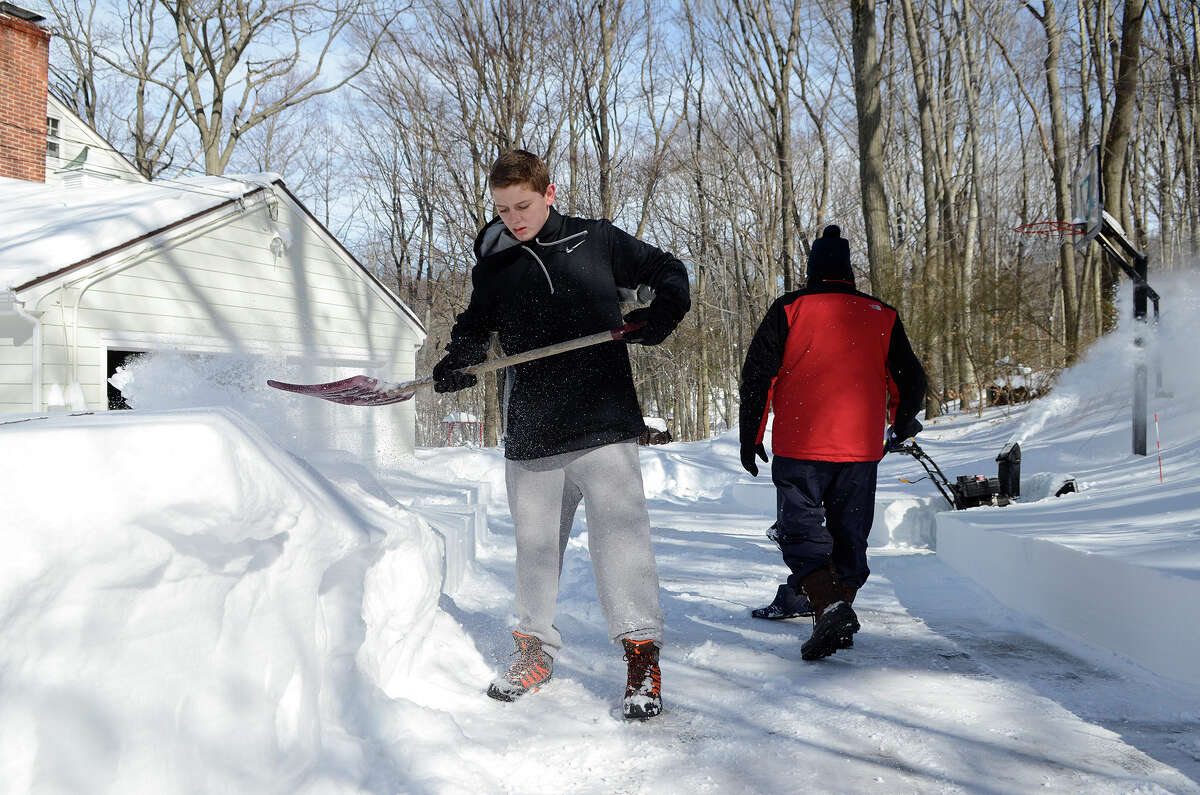 Jake Tymon, 14, helps neighbors shovel out their driveway in Southport, CT on Sat., Feb. 9, 2013, following a blizzard that dumped up to three feet of snow across the state.