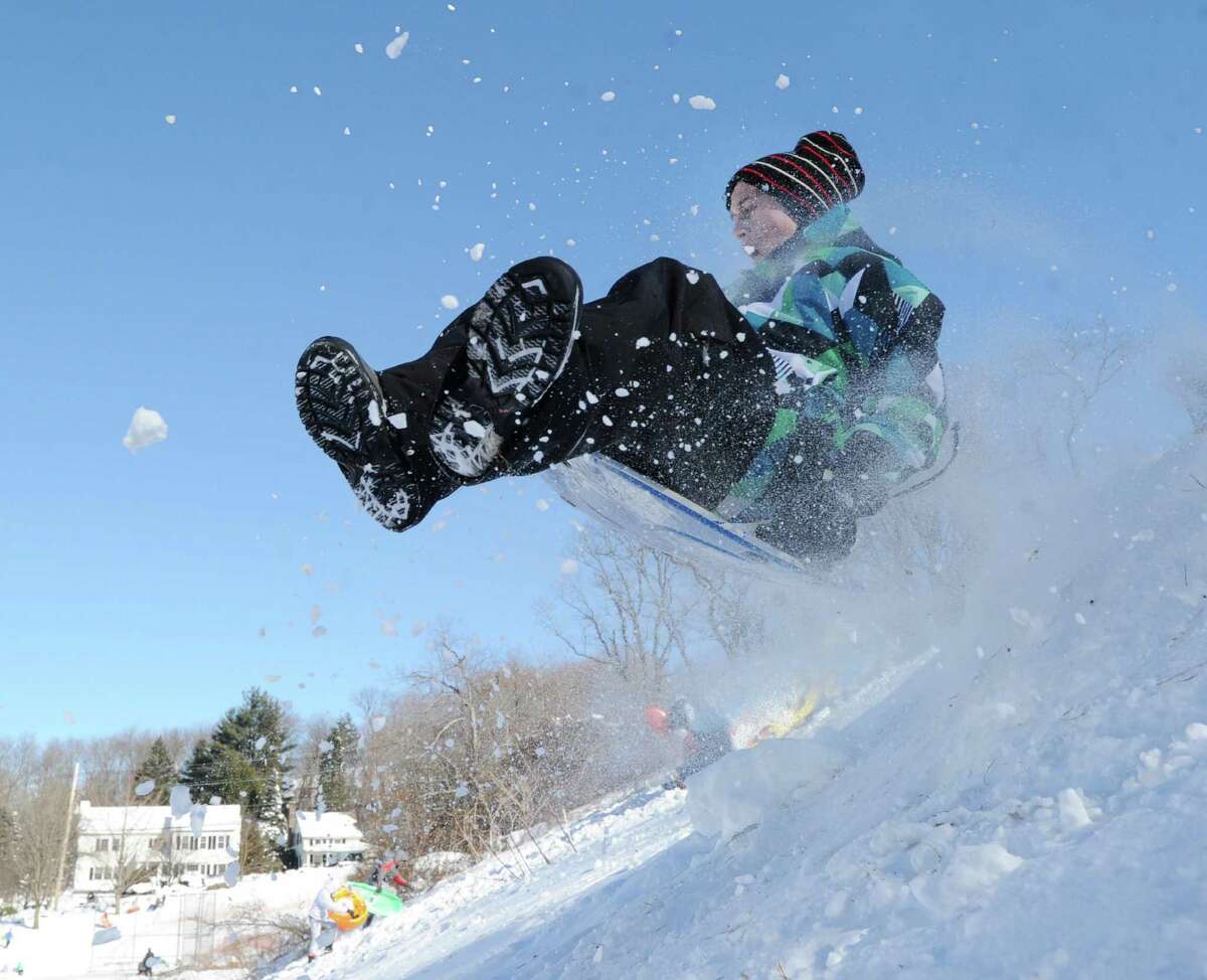 A boy on a sled jumps over a ramp on the hill near the Western Greeenwich Civic Center during the aftermath of the blizzard that hit Greenwich, Saturday, Feb. 9, 2013.