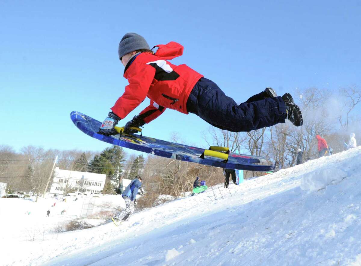 A boy on a sled jumps over a ramp on the hill near the Western Greeenwich Civic Center during the aftermath of the blizzard that hit Greenwich, Saturday, Feb. 9, 2013.