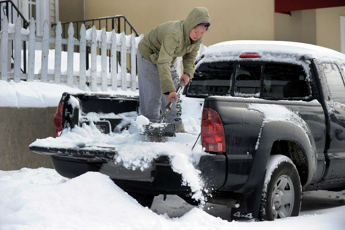 Jesse Wong cleans out the snow in the back of her truck on Grassy Plain Road in Bethel, Conn. Saturday, Feb. 9, 2013. A blizzard dumped almost two feet of snow in the Greater Danbury area Friday into Saturday morning.