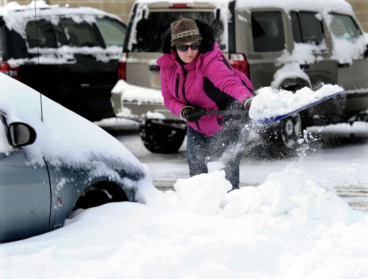 Michele Conderino of Bethel digs out her friends car in a parking lot on Greenwood Ave. in Bethel, Conn. Saturday, Feb. 9, 2013. She says someone dug her out so she is passing on the favor. A blizzard dumped almost two feet of snow on the Danbury area Friday and early Saturday morning.