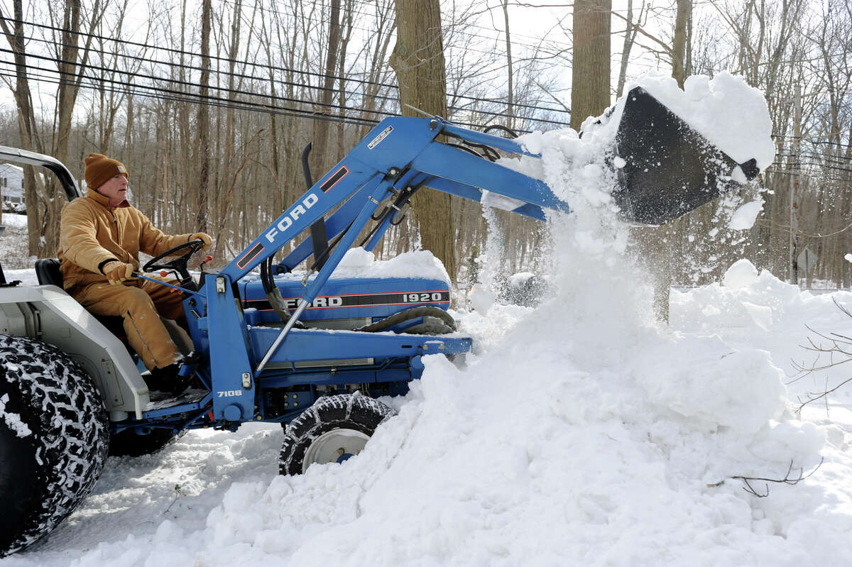 Roger Faille of Redding plows his neighbor's driveway on Route 107 in Redding, Conn. Saturday, after a blizzard dumped almost two feet of snow.