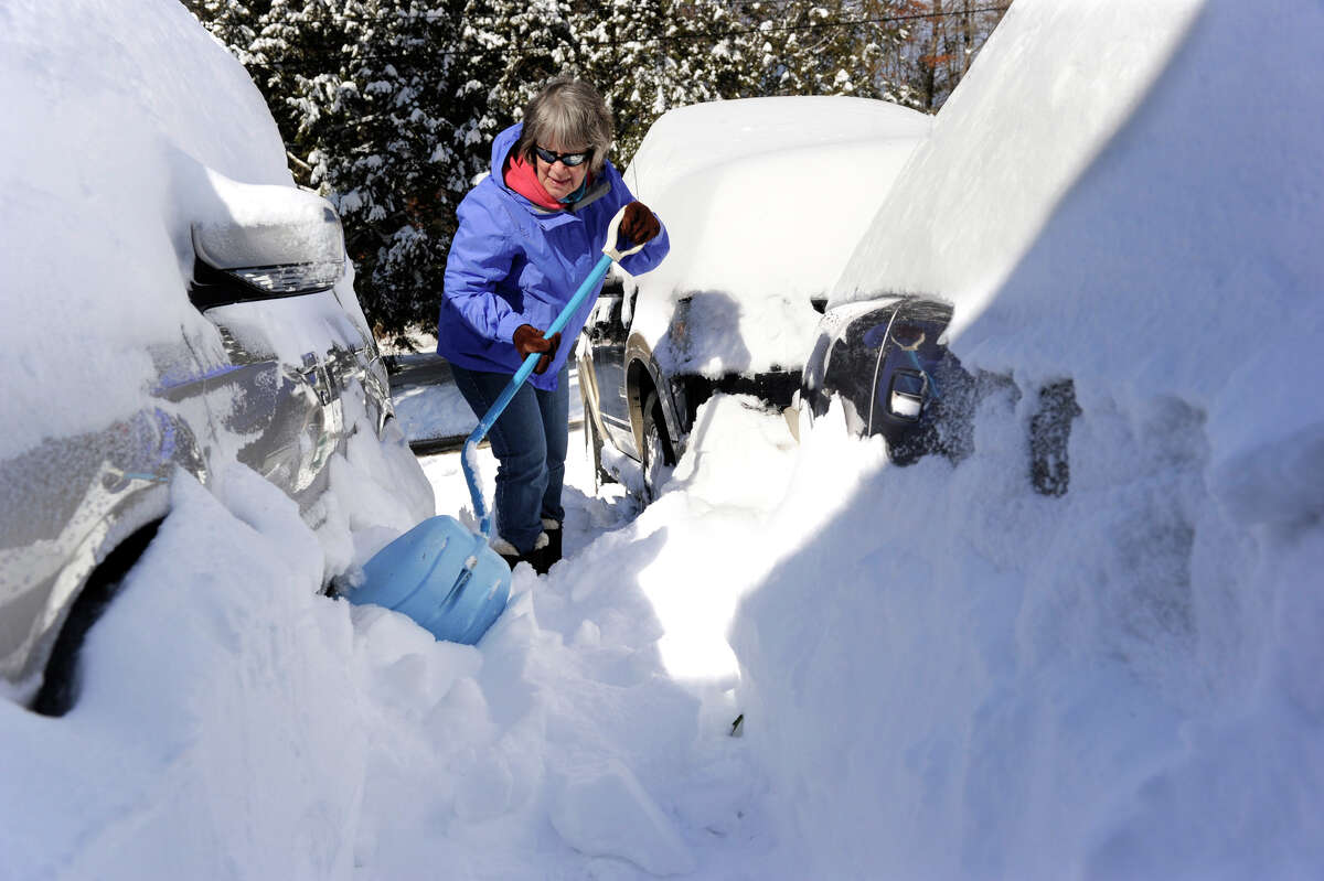 Joan Rothfuss, shovels out her cars on Karen Blvd. in Newtown, Conn. aftera blizzard dumped almost two feet of snow on the area Friday into Saturday morning, Feb. 9, 2013.