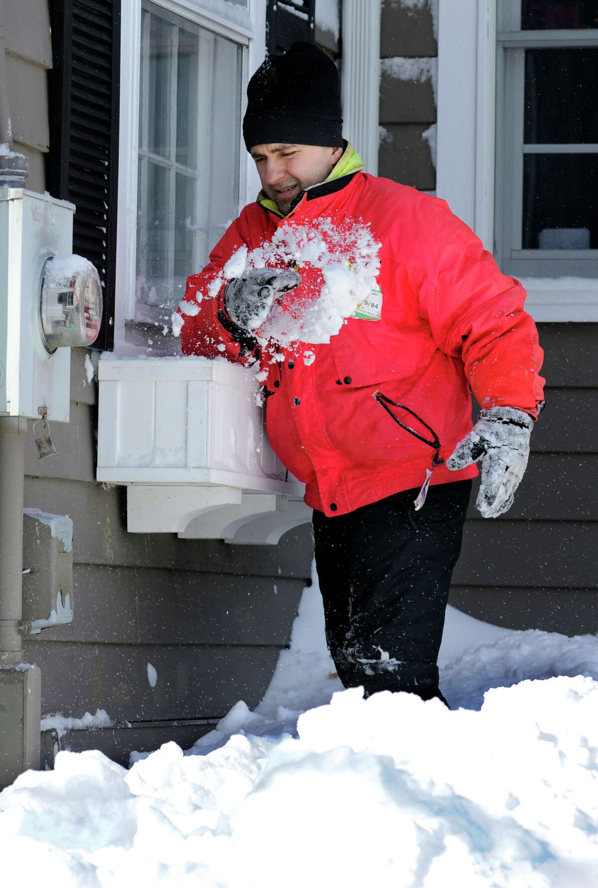 Mark Forlenzo, cleans snow out of the flower boxes around his home on Glover Avenue in Newtown after a blizzard dumped two feet of snow on the area Friday into Saturday morning, February 9, 2013.