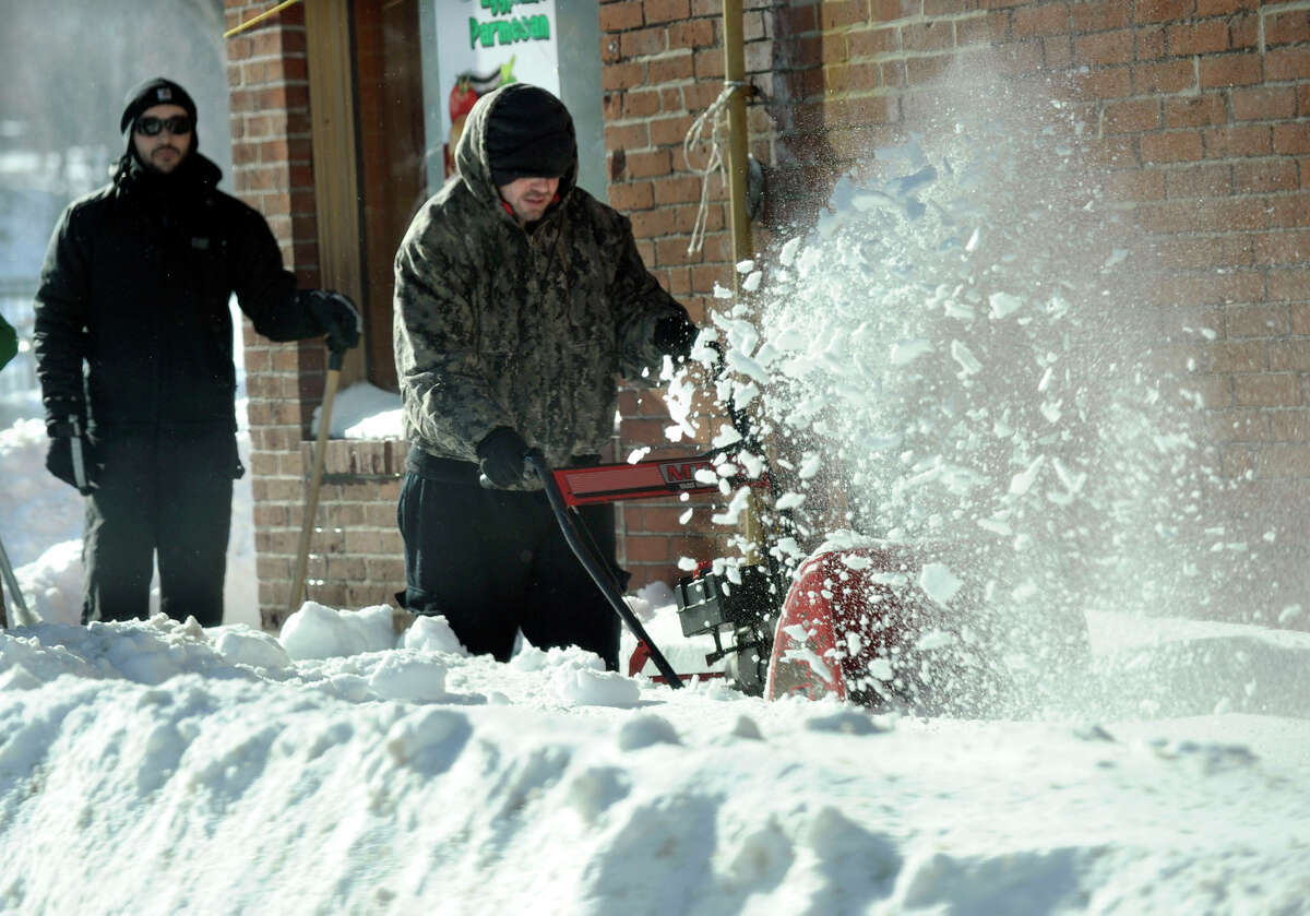 Workers clear the streets of snow in Danbury, Conn. Saturday after a blizzard dumped almost two feet of snow on the area.