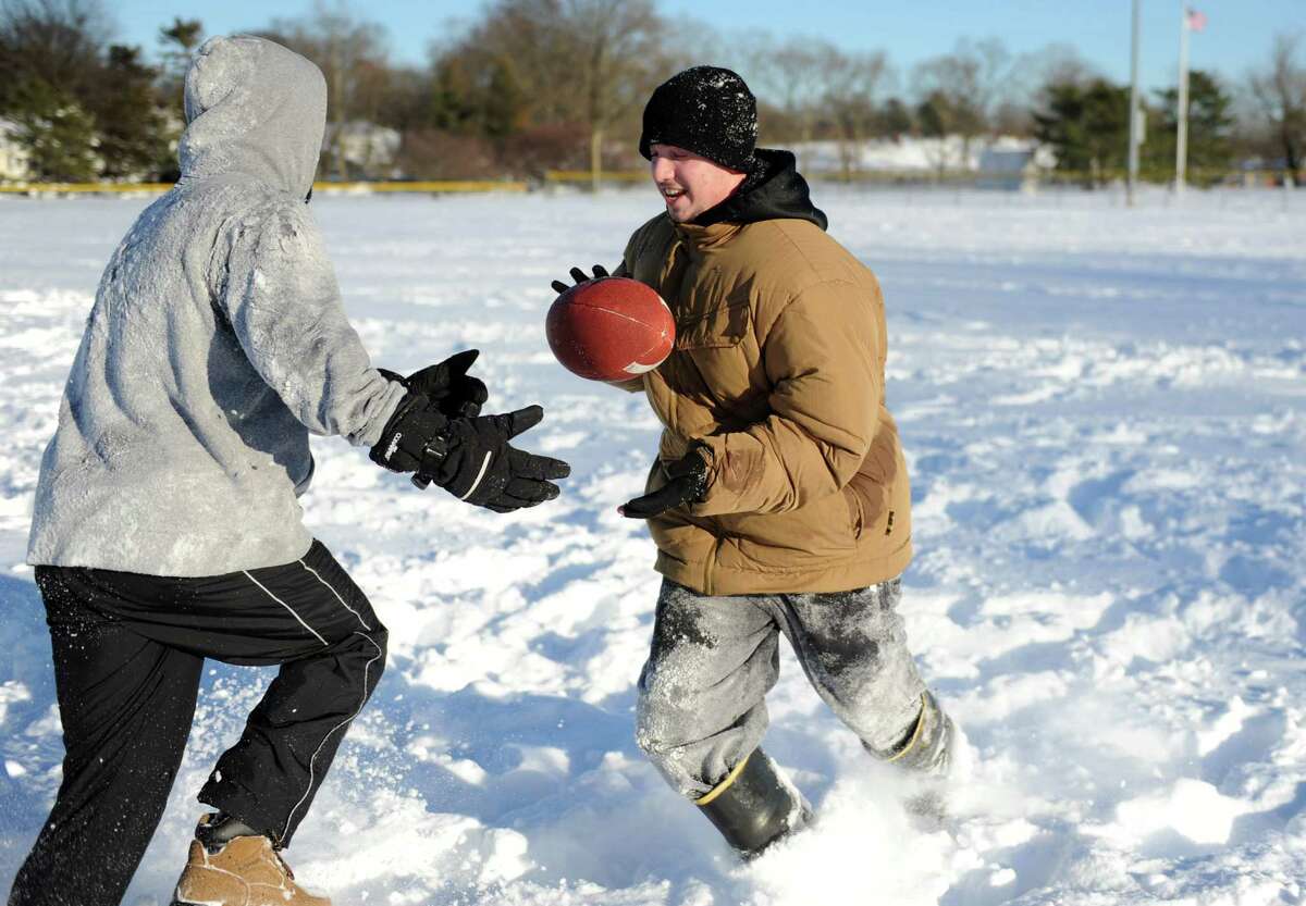 Mario Sciarretta, left, and Anthony Pampena Jr., right, play football in Cummings Park in Stamford, Conn., on Saturday, February 9, 2013.
