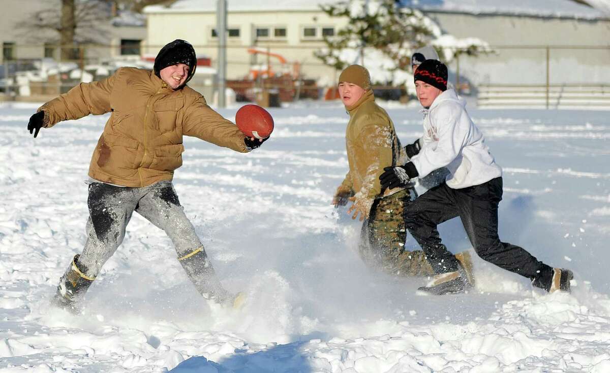 Anthony Pampena Jr., left, Bobby Truong, center, and Timothy Mira, right, play football in Cummings Park in Stamford, Conn., on Saturday, February 9, 2013.