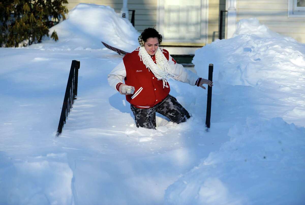 Marisa Conte trudges through the snow in Derby, Conn. to bring her neighbor some eggs Saturday, Feb. 9, 2013 following a severe blizzard that dumped up to three feet of snow across the state.