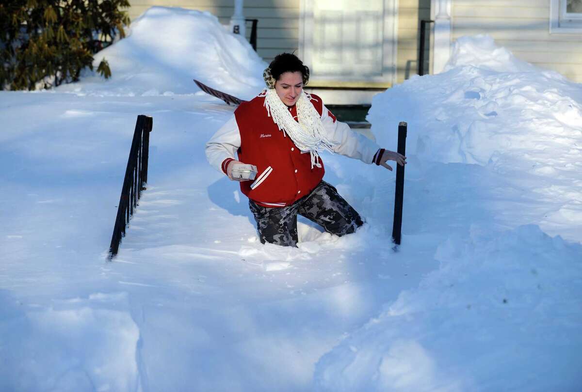 Marisa Conte trudges through the snow in Derby, Conn. to bring her neighbor some eggs Saturday, Feb. 9, 2013 following a severe blizzard that dumped up to three feet of snow across the state.