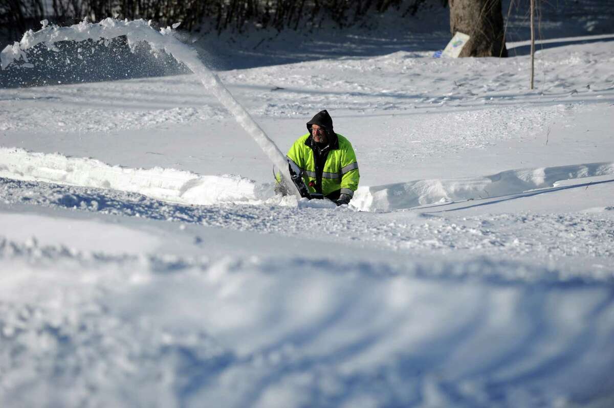 John Sonsini uses a snowblower to clear his sidewalk in Derby, Conn. as residents face massive snow removal Saturday, Feb. 9, 2013 following a severe blizzard that dumped up to three feet of snow across the state. While Sonsini managed to clear his driveway and walkways, his road still had several feet of snow covering it.