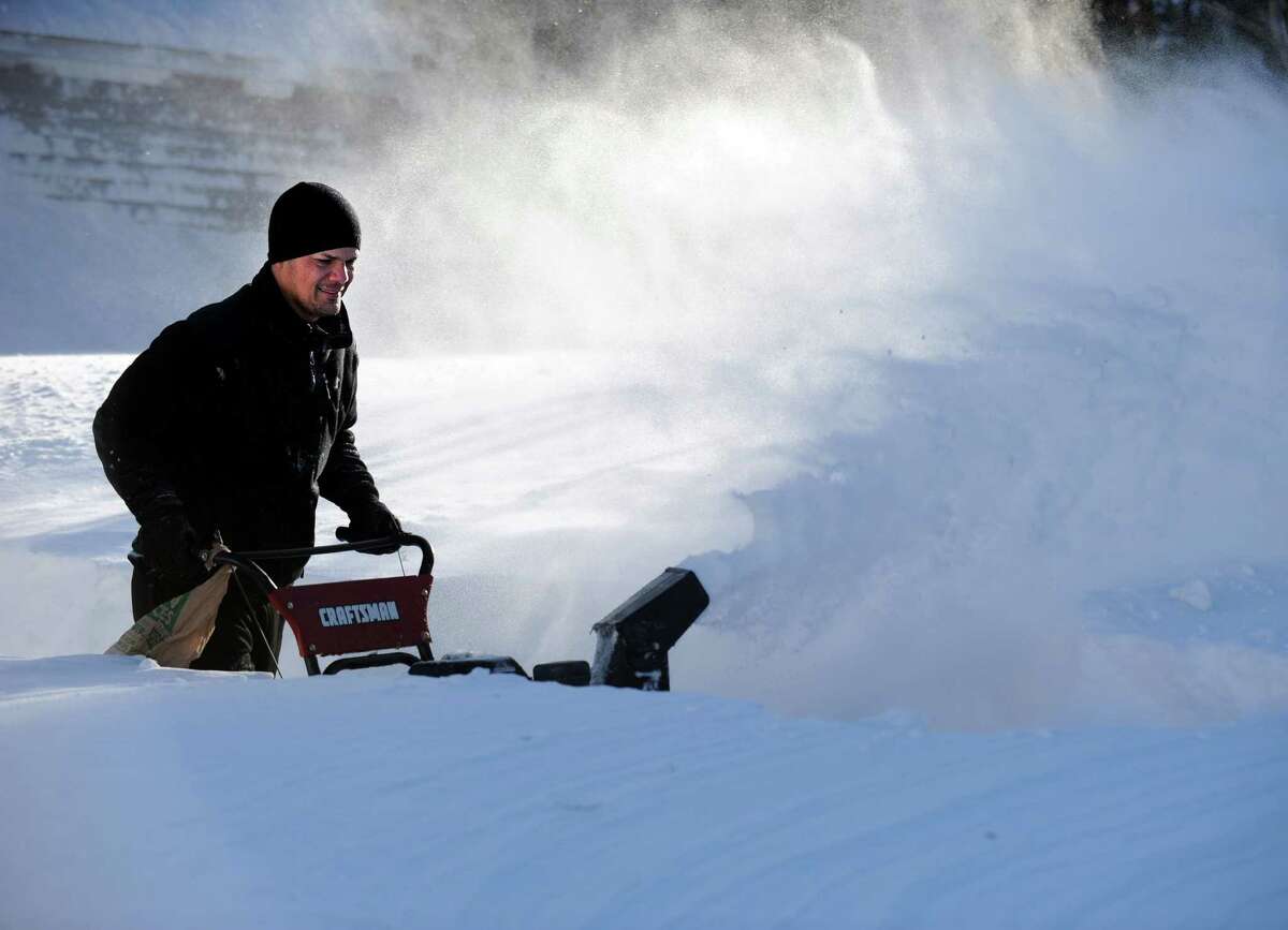 Tony Colon uses a snowblower to clear his driveway in Derby, Conn. as residents face massive snow removal Saturday, Feb. 9, 2013 following a severe blizzard that dumped up to three feet of snow across the state.