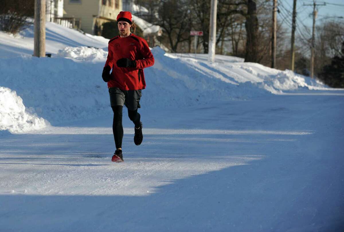 Timothy Milenkevich, of Ansonia, runs down Hawthorne Avenue in Derby, Conn. Saturday, Feb. 9, 2013 following a severe blizzard that dumped up to three feet of snow across the state.