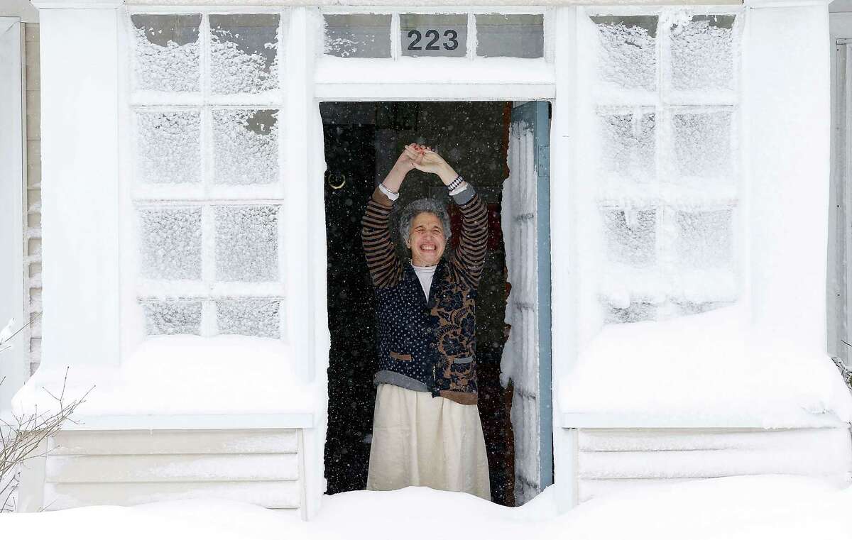 A woman reacts to the snow after opening her front door on February 9, 2013 in Boston, Massachusetts. The powerful storm has knocked out power to 650,000 and dumped more than two feet of snow in parts of New England.
