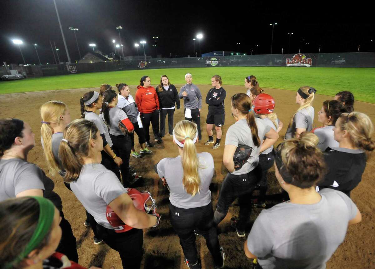 Head coach Holly Bruder,center, back, , and her coaching staff talk to the players after practice. Lamar softball is having it's first season since 1987. Thursday night found the girls team getting practice done at the Ford Park complex. They will open their 2013 season on Saturday. Dave Ryan/The Enterprise