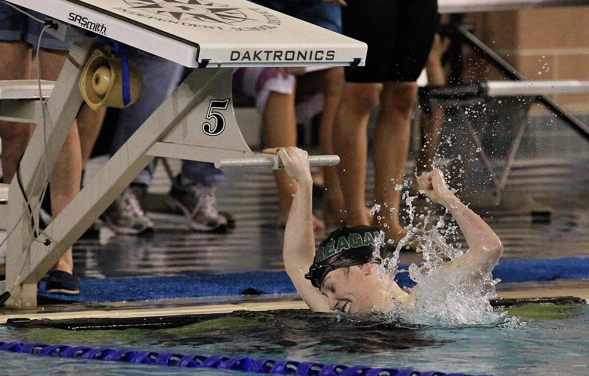 Reagan's Kristina Domaschofsky celebrates after finishing first in the 100 yard butterfly at the Region VII-5A Championship swim meet at Josh Davis Natatorium on Saturday, Feb. 9, 2013. Domaschofsky finished with a time of 56.80.
