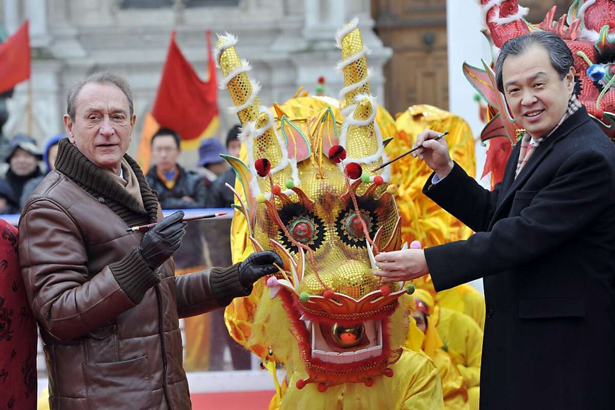 Paris Mayor Bertrand Delanoe (left) and China's ambassador in France Kong Quan traditionally paint the eye of a dragon in front of Paris City Hall during the Chinese New Year celebrations on February 10, 2013 in Paris. Chinese communities world wide traditionally welcomed in the 'Year of the Snake'.
