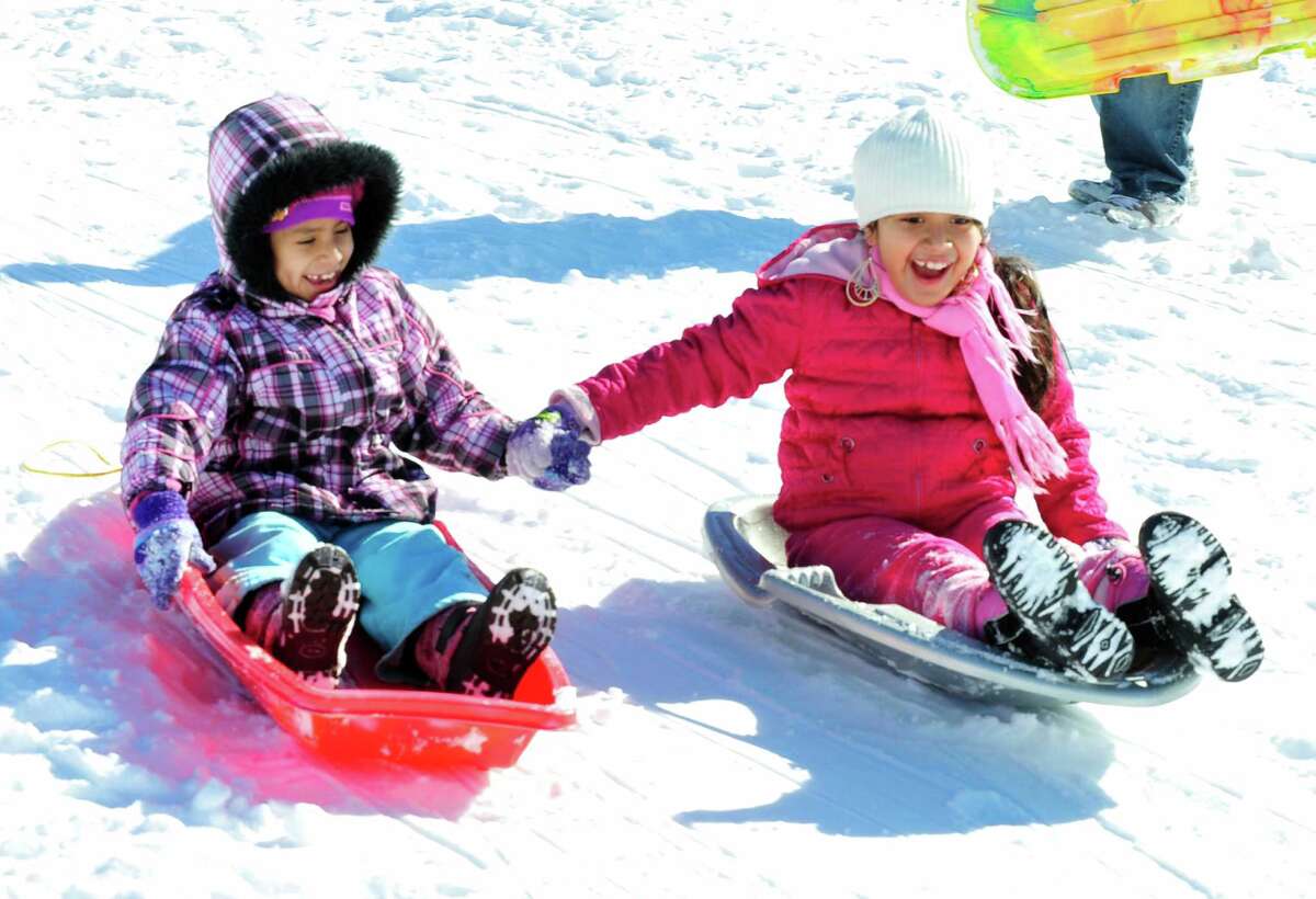 Daisy Salazar, left, and her friend, Gina Panez, both 7, sled together at Broadview Middle School in Danbury, Sunday, Feb. 10, 2013.