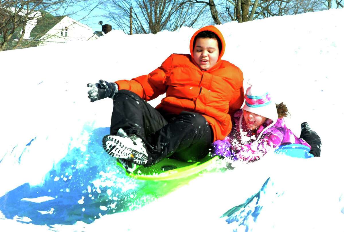 Elijah Wilson, 14, and his sister, Alexandria, 10, go over a jump while sledding at Broadview Middle School in Danbury, Sunday, Feb. 10, 2013.