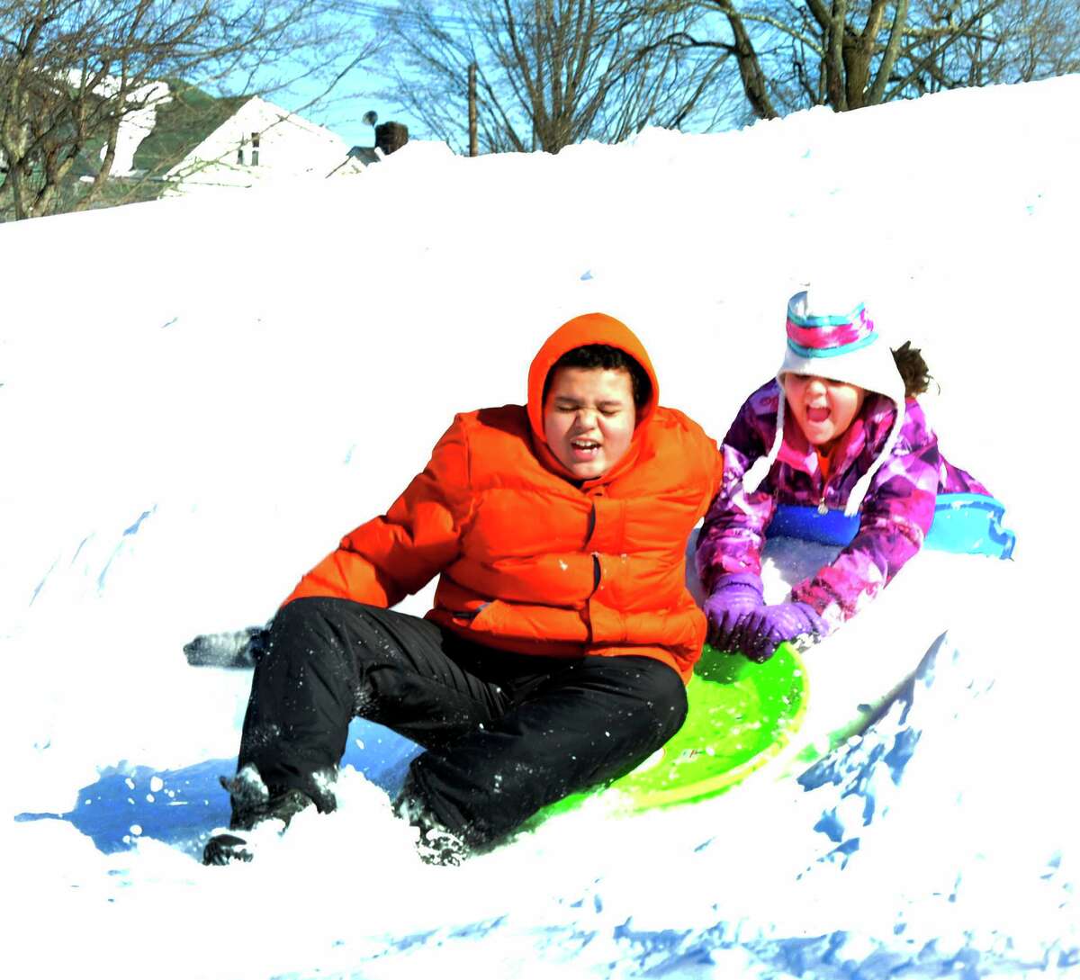 Elijah Wilson, 14, and his sister, Alexandria, 10, go over a jump while sledding at Broadview Middle School in Danbury, Sunday, Feb. 10, 2013.