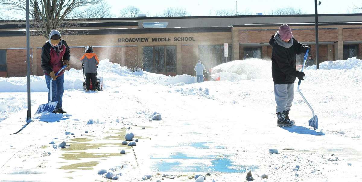 Workers clear snow outside Broadview Middle School in Danbury, Sunday, Feb. 10, 2013.