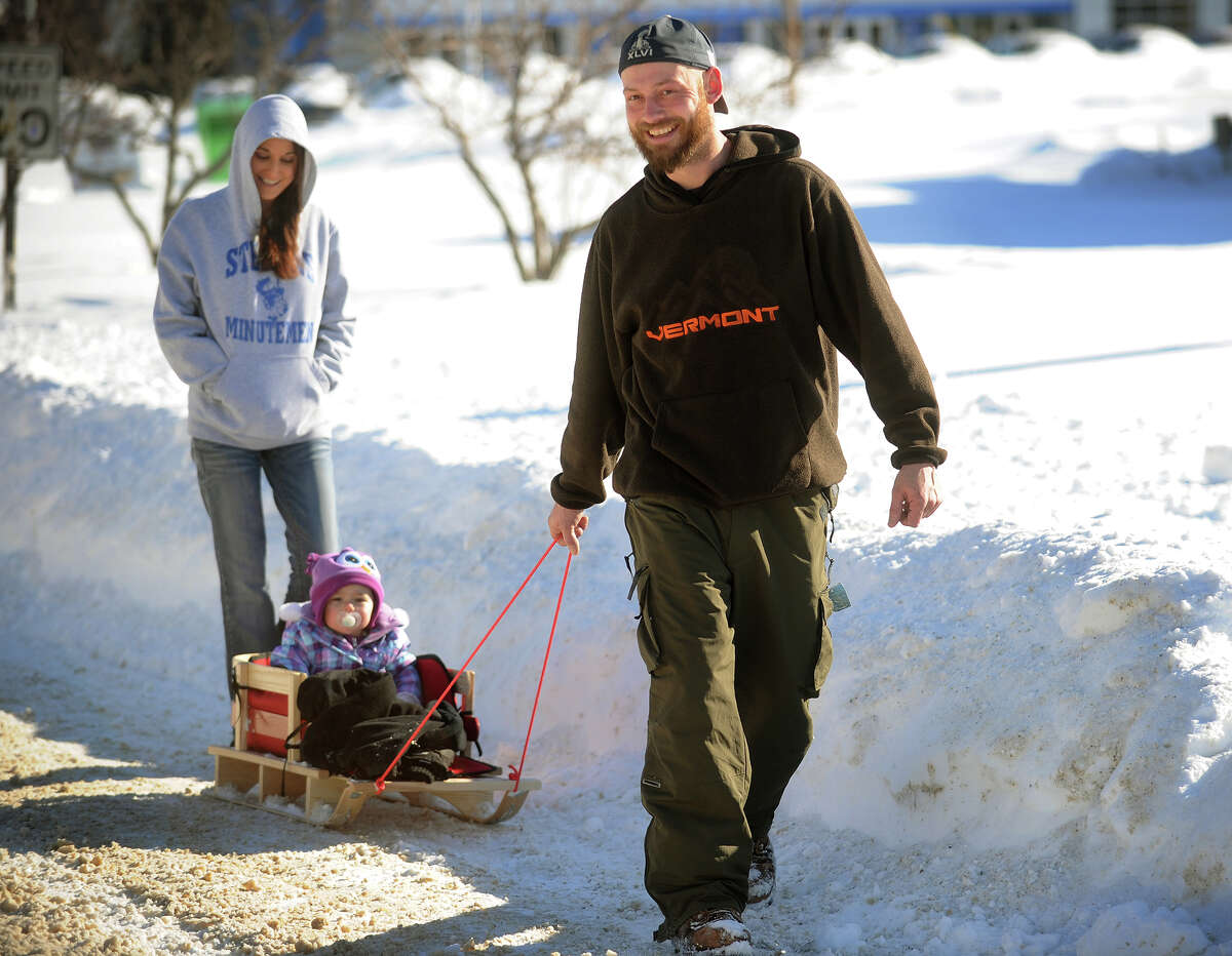 Their street still unplowed, Matt and Kim Lanier and their daughter Jenna, 16 months, head out on foot on the Boston Post Road in Milford, Conn. on Sunday, February 10, 2013.