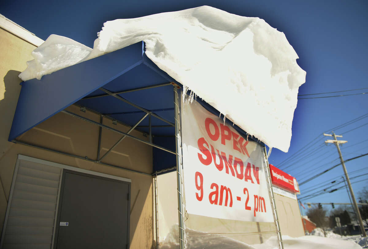An overhang of snow appears ready to avalanche on the awning of a Boston Post Road business in Milford, Conn. on Sunday, February 10, 2013.