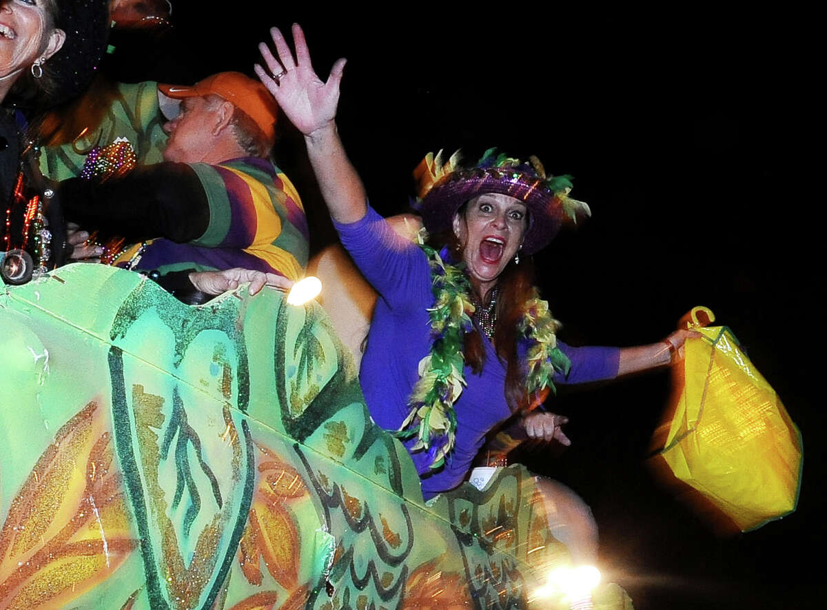 Marianne Petry throws beads from the Beer Meister float as they parade down Proctor Street in Port Arthur during the Total Krewe of Aurora Parade on Saturday, February 9, 2013. Photo taken: Randy Edwards/The Enterprise