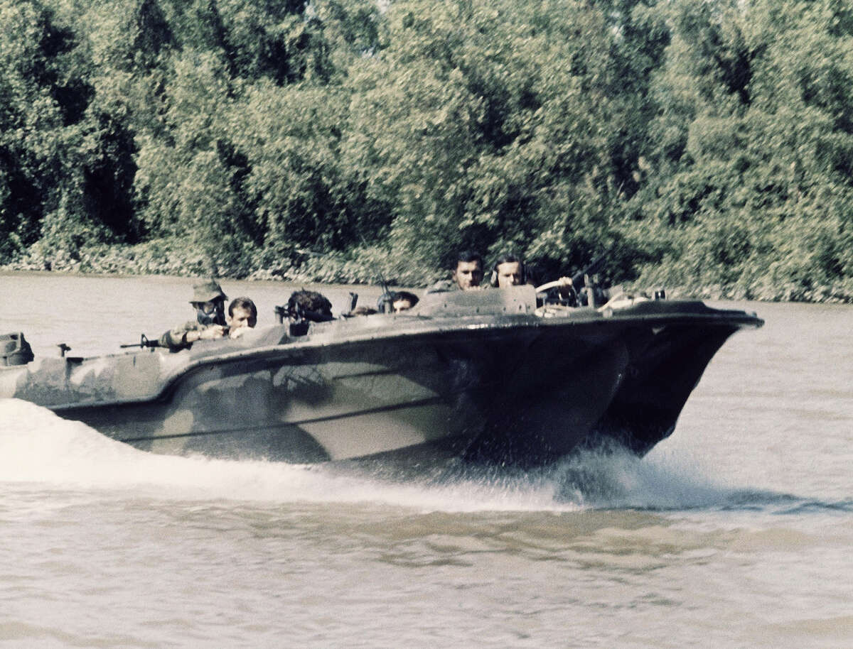 In this image provided by the U.S. Navy, members of U.S. Navy Seal Team One move down the Bassac River in a Seal Team Assault Boat (STAB) during operations in south of Saigon, Vietnam in January 1969. (AP Photo/U.S. Navy)