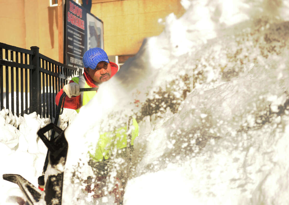 Roberto Cuaya uses a snow blower to clear sidewalks in the Bijou Square development of Fairfield Avenue in Bridgeport, Conn. on Sunday, February 10, 2013.