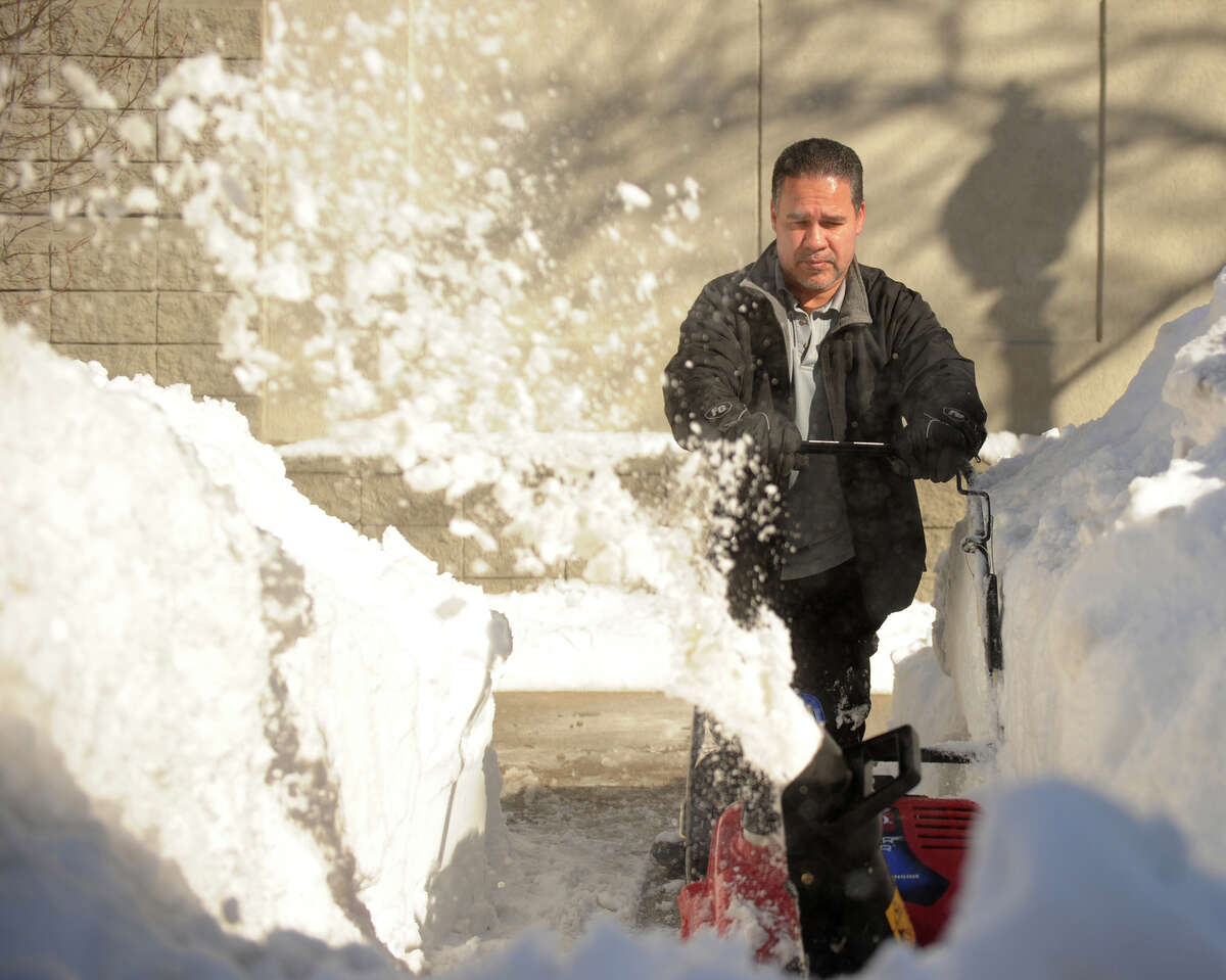 Mike Marrero of Bridgeport uses a snow blower to clear sidewalks in front of the Holiday Inn on Main Street in downtown Bridgeport, Conn. on Sunday, February 10, 2013.