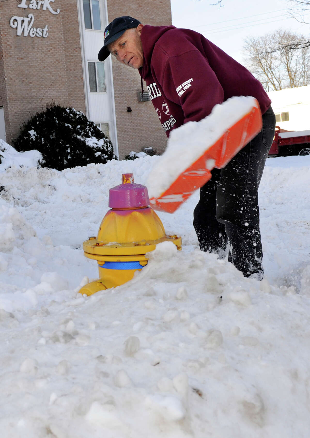Rick Lavoie, 52, of Danbury, clears snow from a semi-buried fire hyrant on Park Avenue in Danbury, Conn. Sunday, February 10, 2013. A blizzard dumped almost two feet of snow on the Danbury area Friday and Saturday.