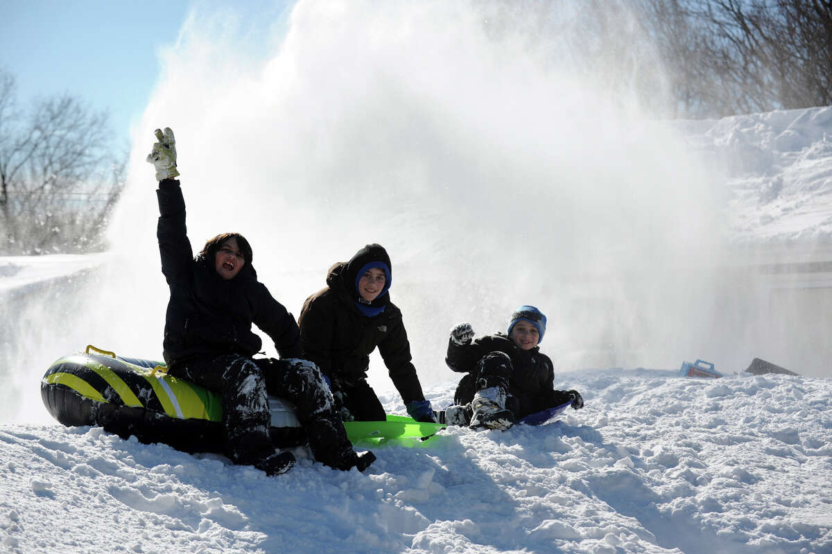 From left, Riley Webb, 11, Joe Monte, 10, and Chris Monte, 7, have fun on a mountain a recently plowed snow in Stratford, Conn., Feb. 10th, 2013.