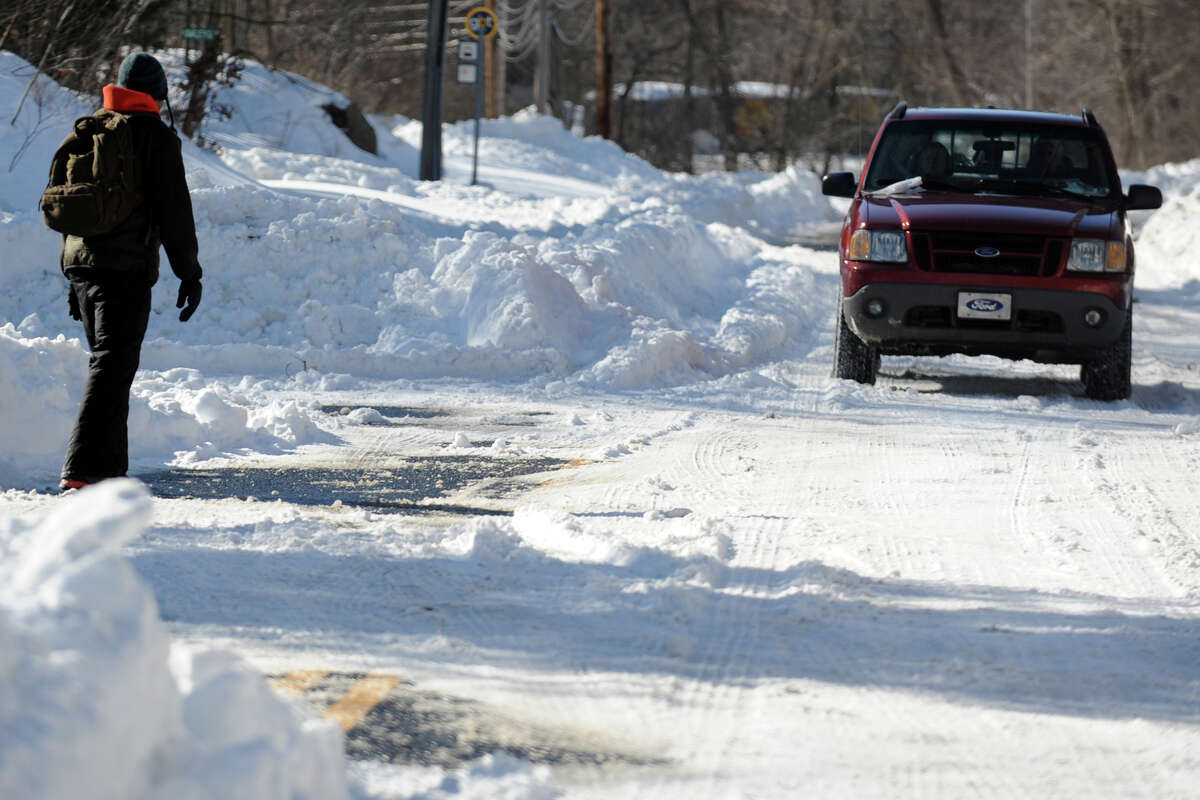 A pedestrian uses caution as he walks along Hawley Lane, in Stratford, Conn., Feb. 10th, 2013.